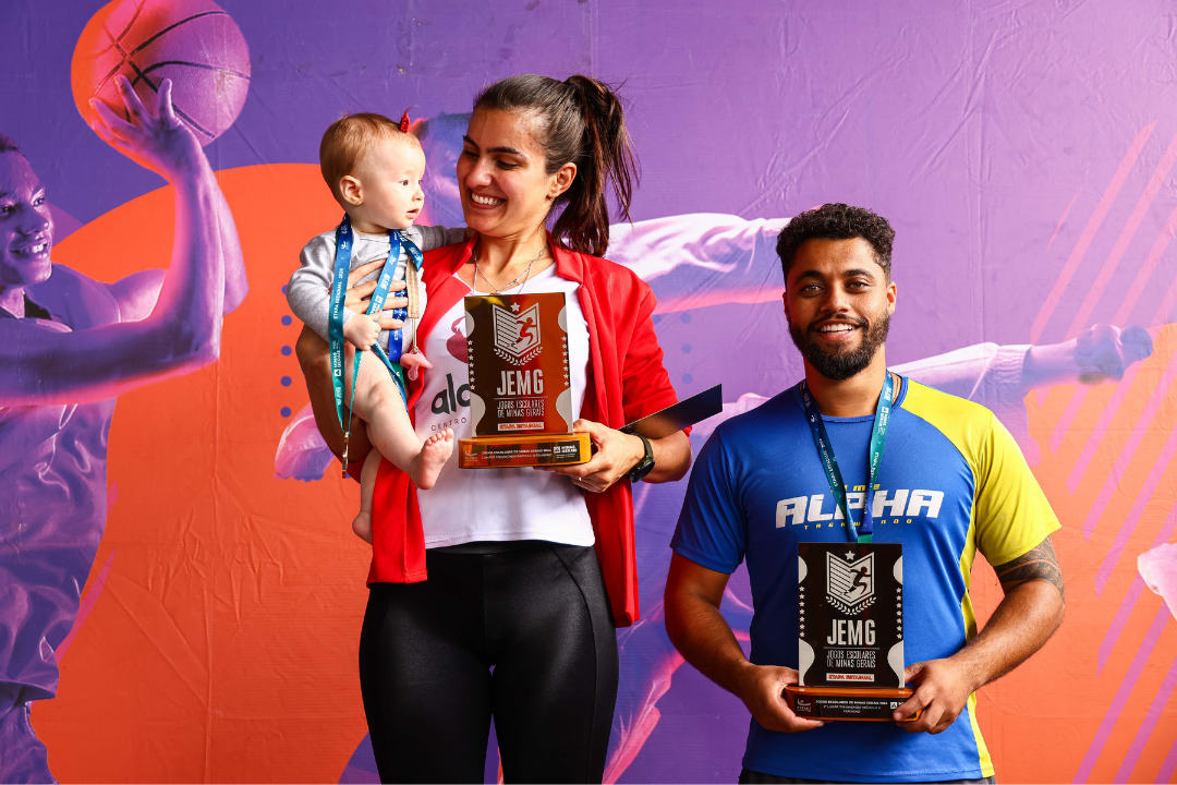 Eduarda com troféu JEMG e bebê no colo